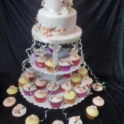 two tier cake and cupcakes at the bottom
