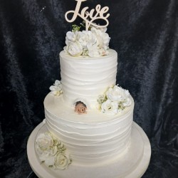 ivory cake with love at the top dog is hiding wedding cake1